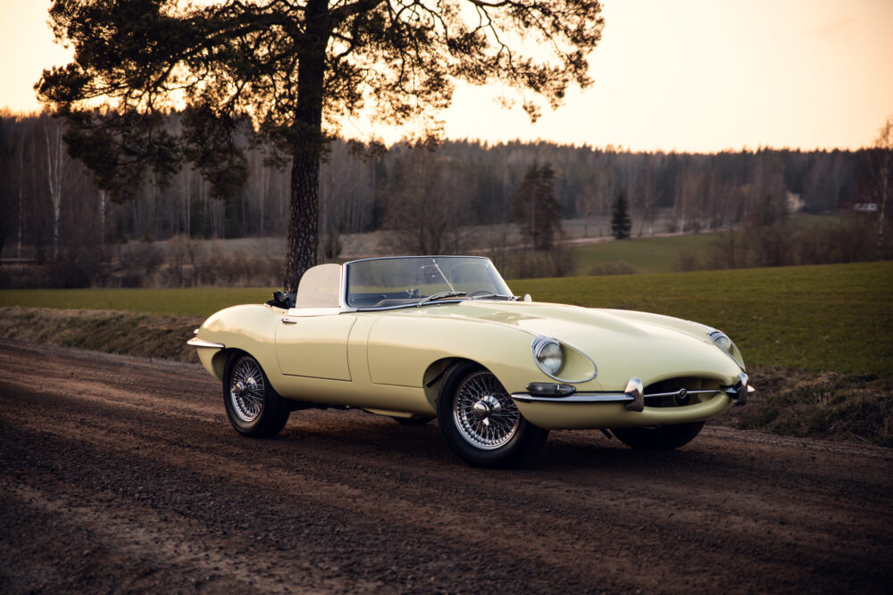 Vintage yellow convertible car on rural road at sunset