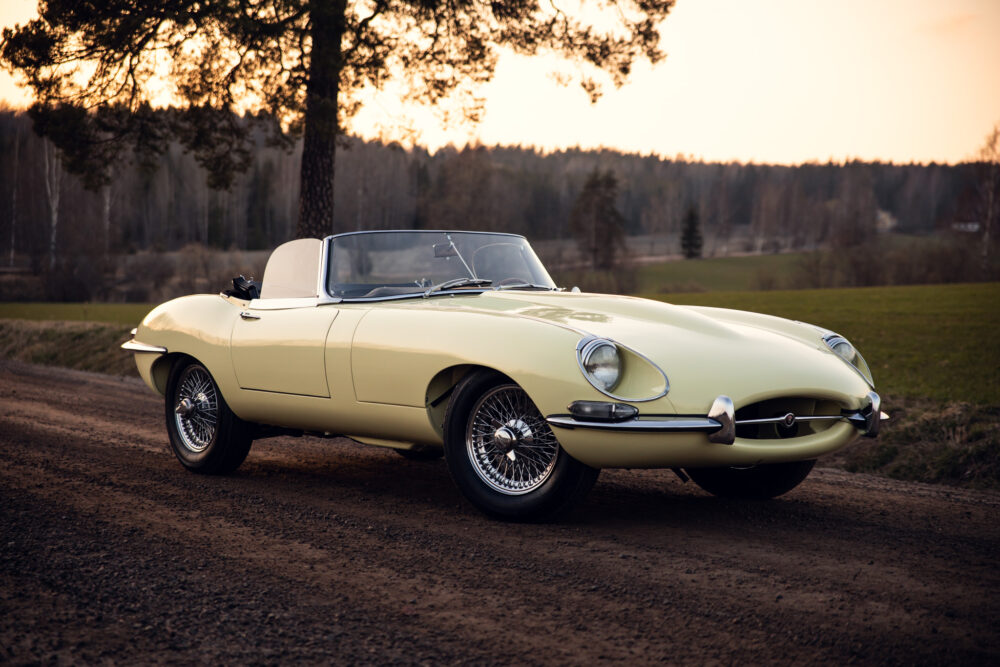 Vintage yellow convertible car on rural road at sunset