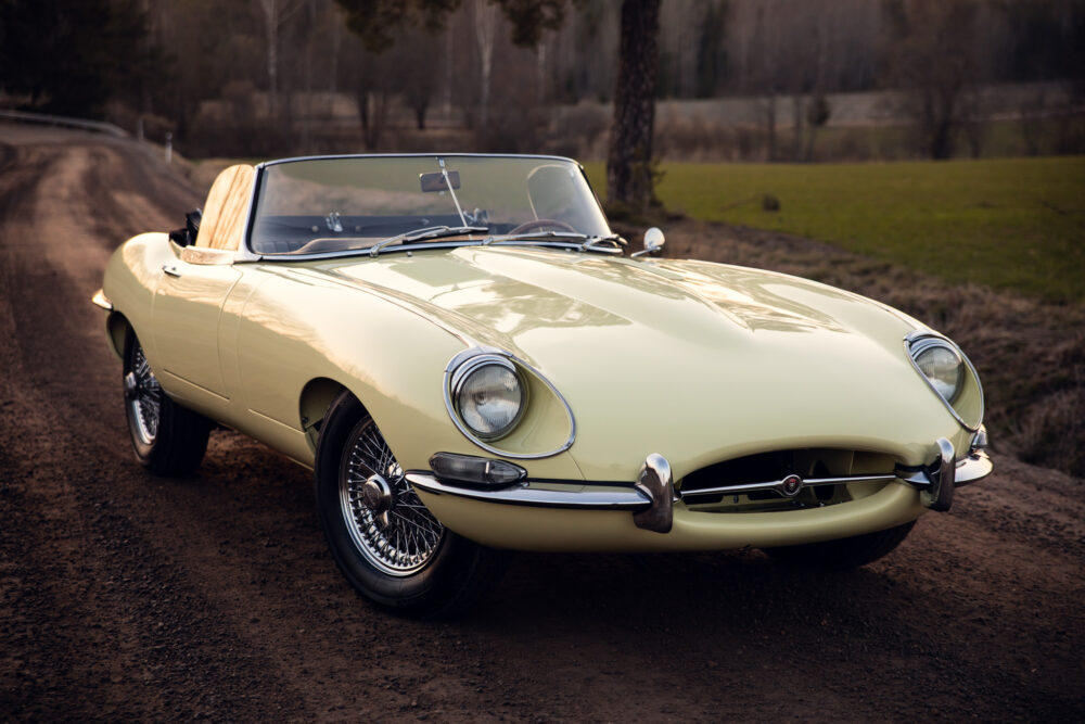 Vintage pale yellow convertible car on rural road