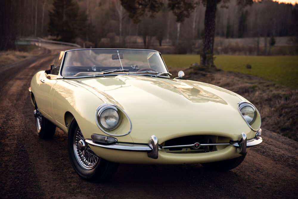 Vintage yellow convertible car on forest roadside