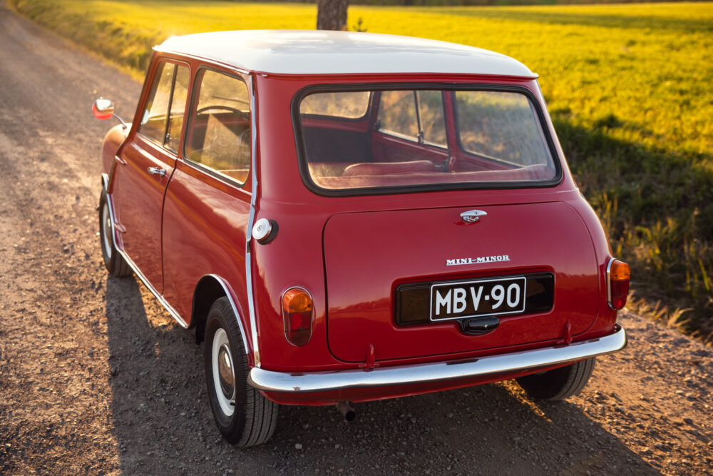 Vintage red Mini Minor car on countryside road