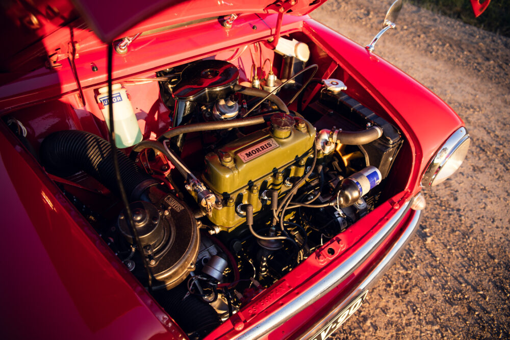 Vintage red Morris car engine open at sunset