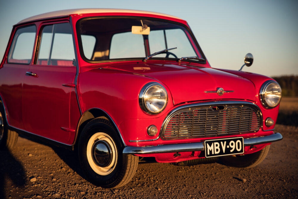 Vintage red Mini Cooper parked outdoors at sunset