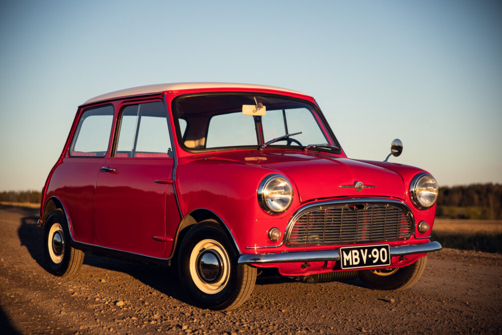 Vintage red Mini car parked outdoors at sunset