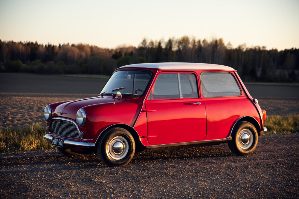 Red vintage Mini Cooper in sunset-lit field