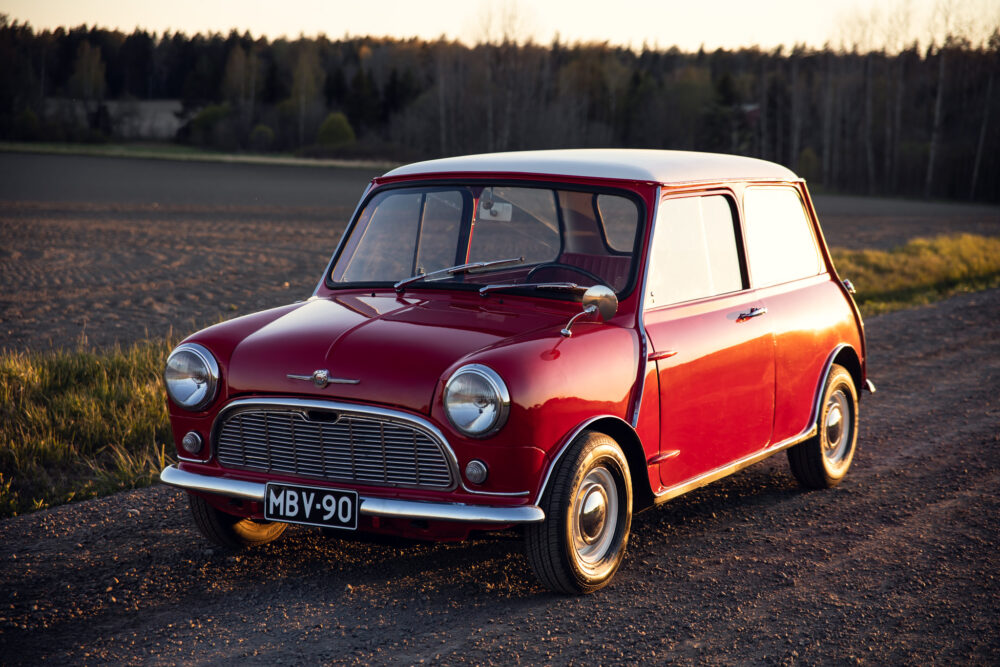 Vintage red Mini Cooper parked in countryside at sunset
