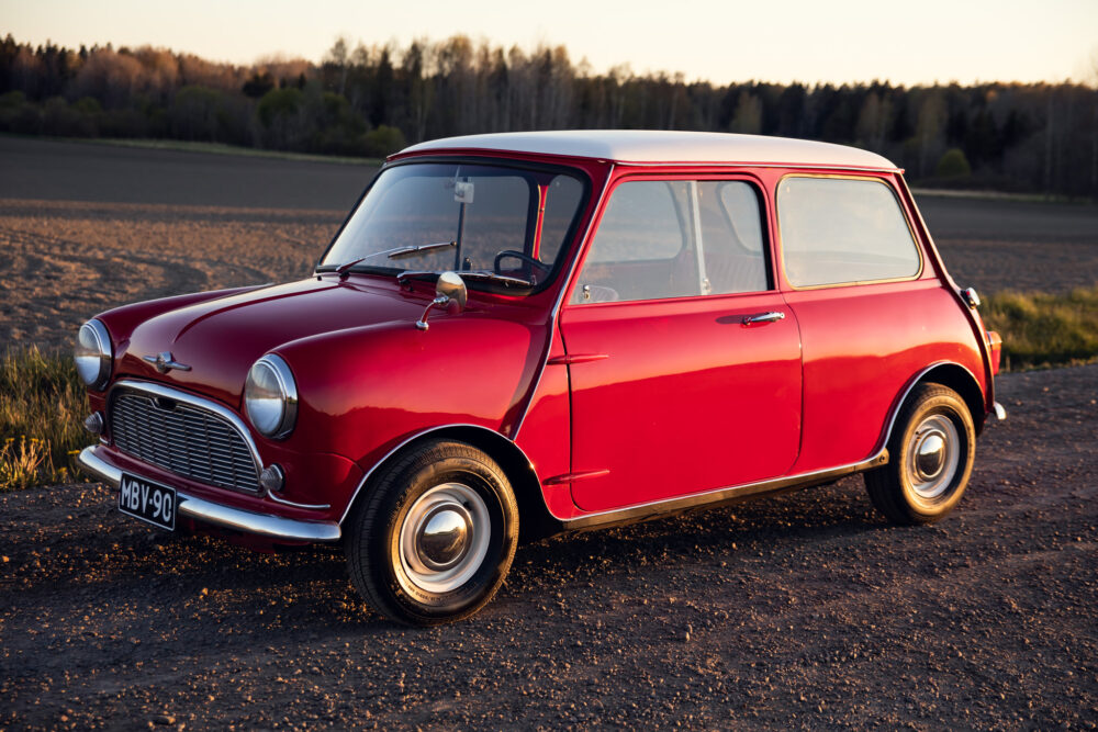 Vintage red Mini Cooper on rural road at sunset