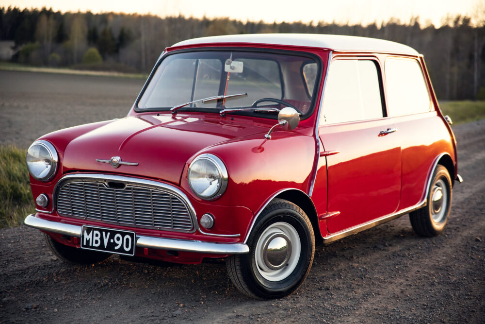 Vintage red Mini Cooper on country road at sunset