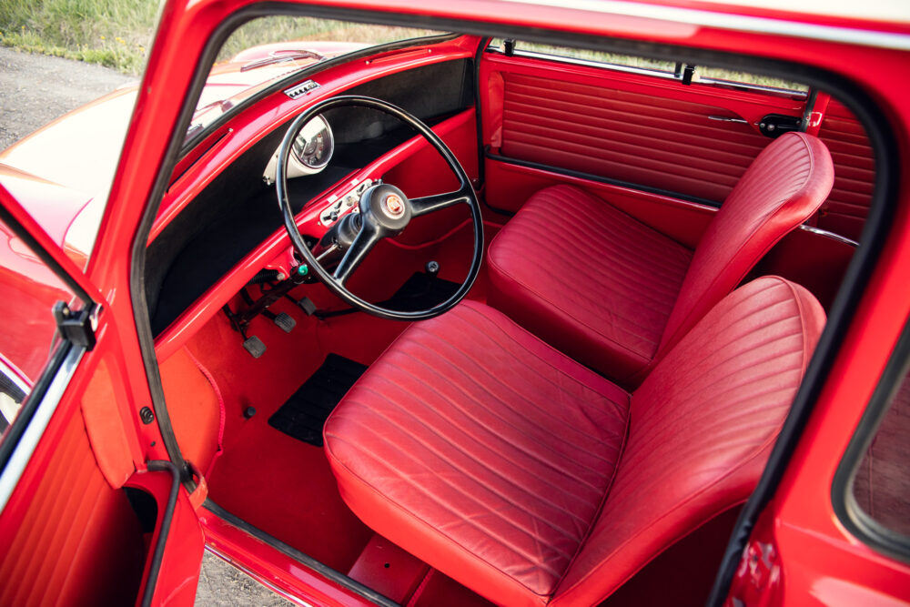 Red vintage car interior with front seats and dashboard