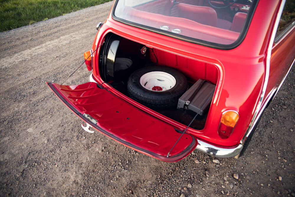 Red vintage car with open trunk showing spare tire
