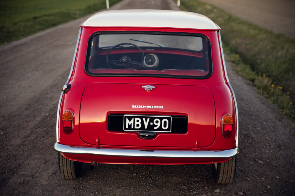 Red vintage Mini Minor car on a rural road