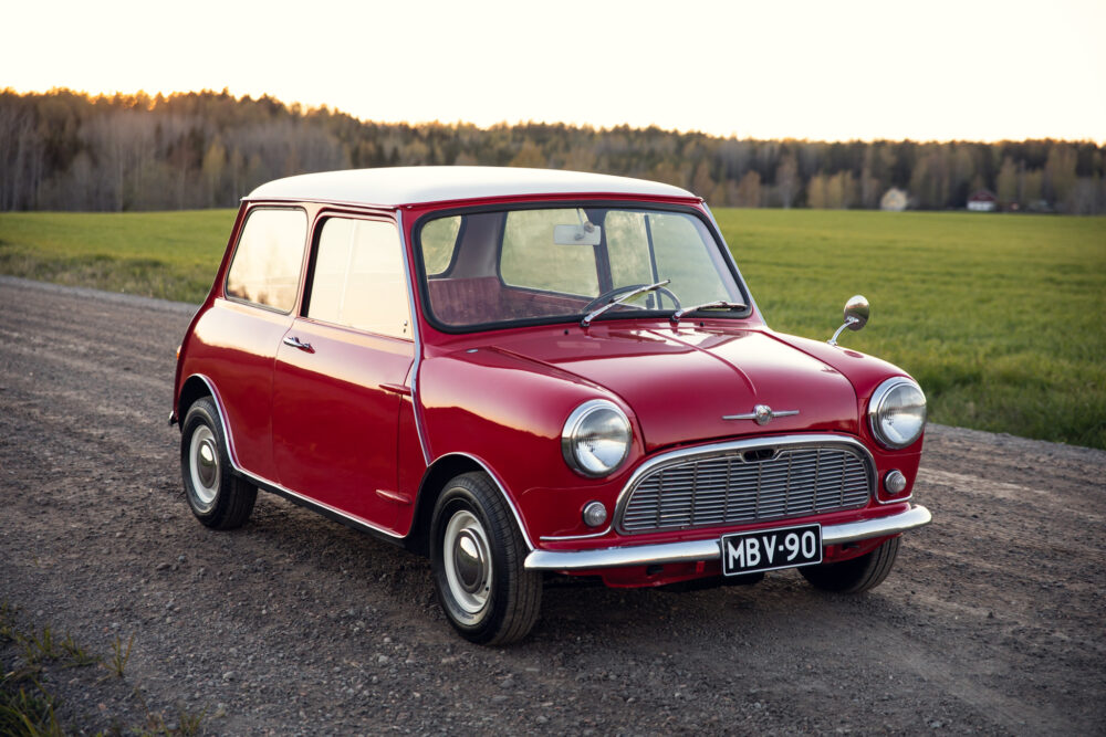 Vintage red Mini Cooper in rural sunset landscape