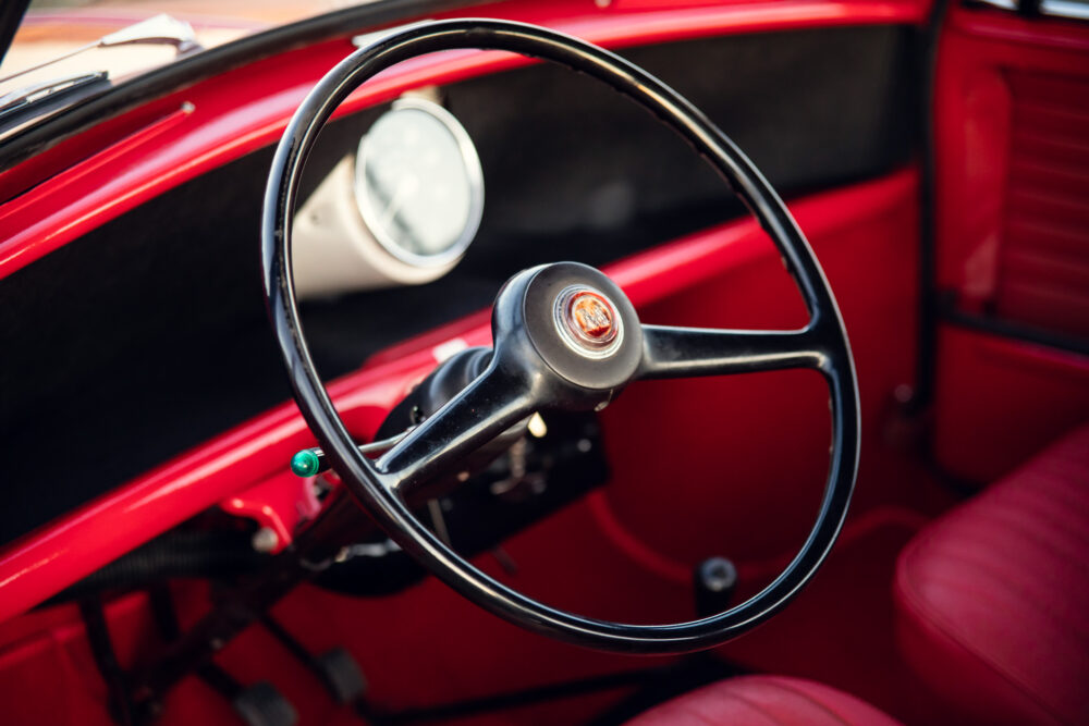Classic red car interior featuring vintage steering wheel
