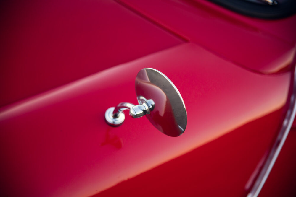Close-up of red car's shiny chrome fuel cap