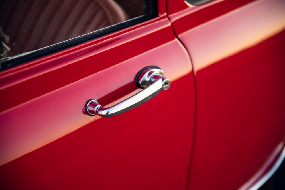 Close-up of vintage red car door handle