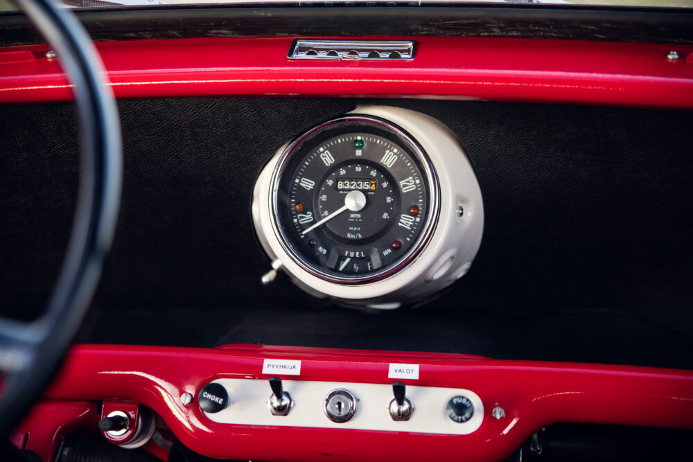 Vintage car dashboard with red detail and speedometer