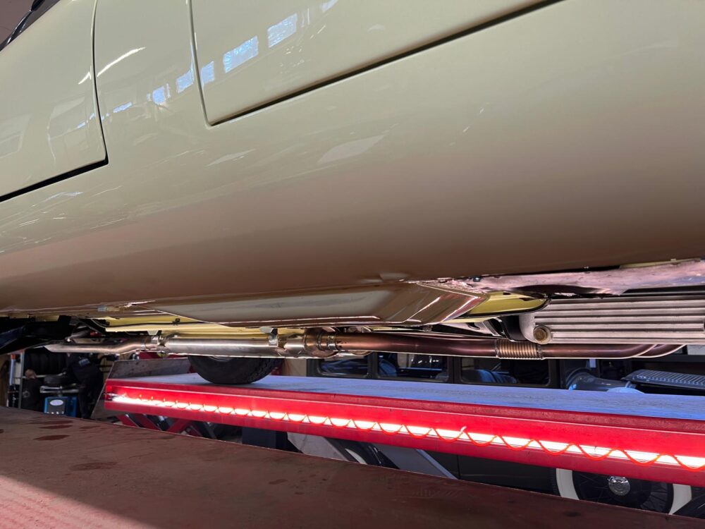 Car underside showing exhaust system on lift