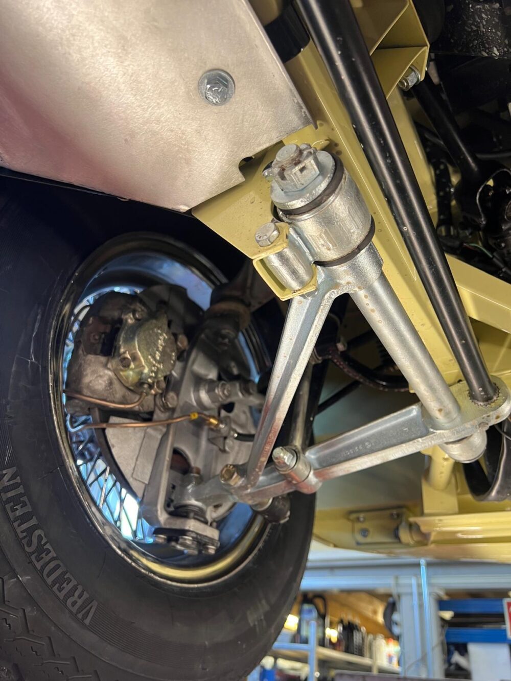 Detailed view of undercarriage and suspension on yellow vehicle