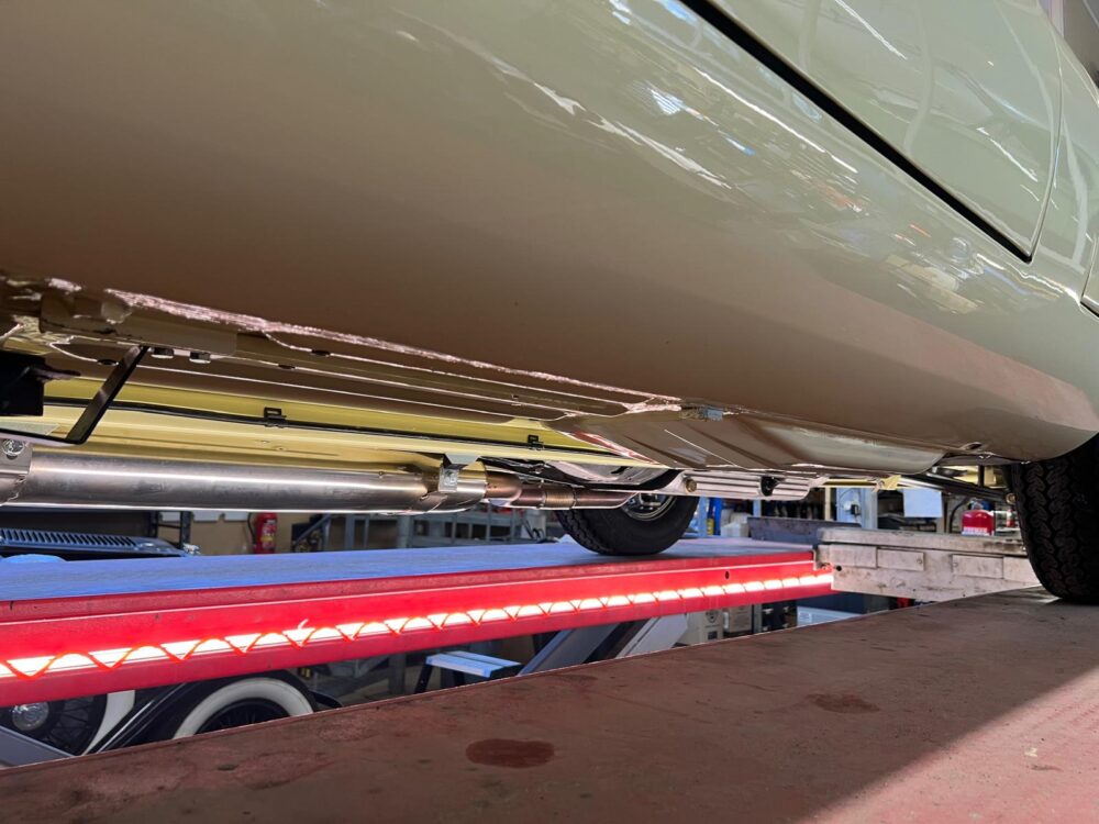Car underside on lift showing exhaust and structure