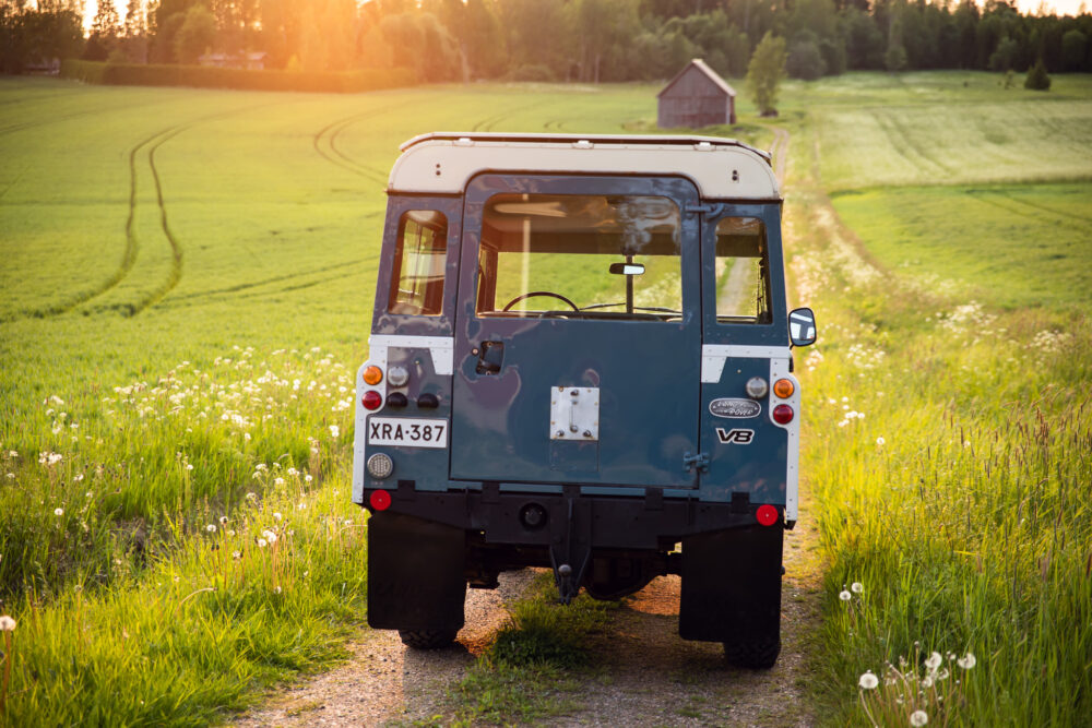 Vintage SUV parked on rural trail at sunset