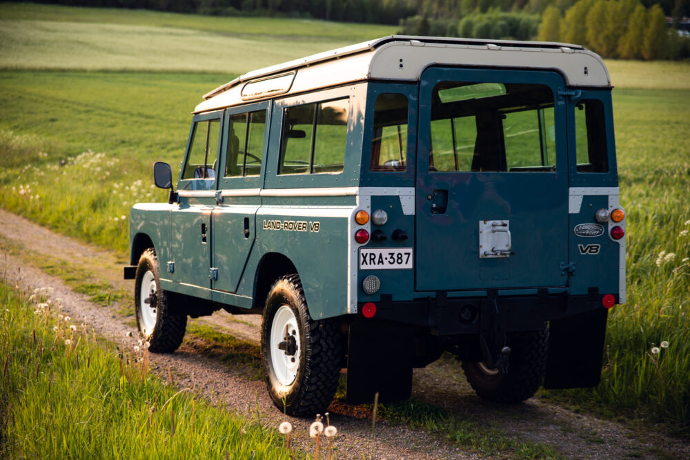 Vintage Land Rover parked in a lush green field
