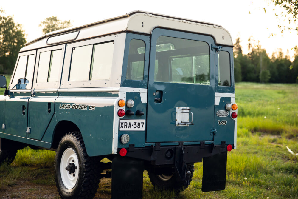 Vintage Land Rover V8 parked in a lush field