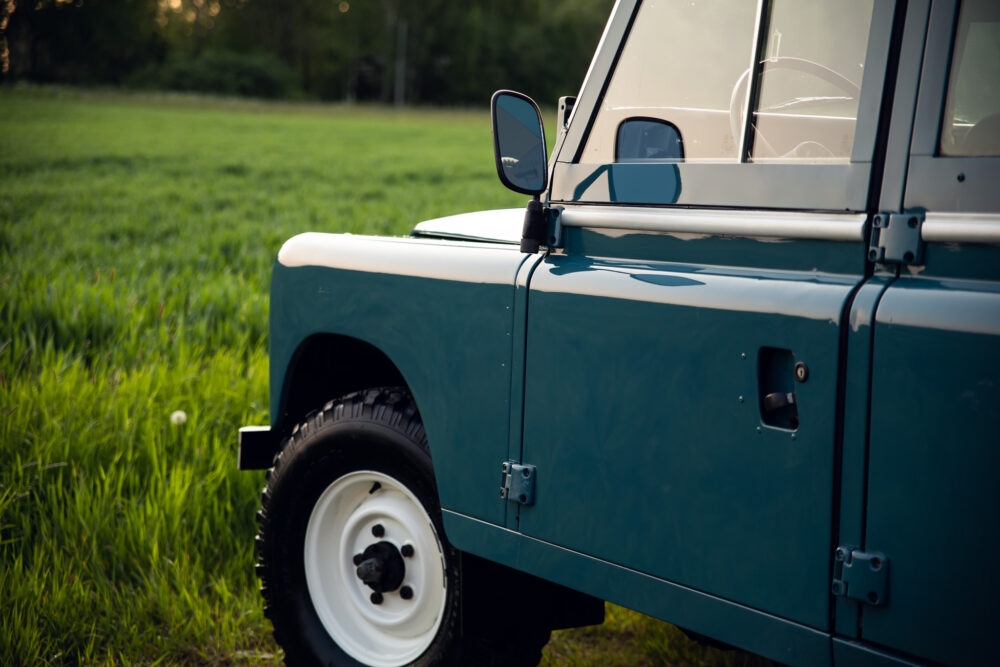 Blue off-road vehicle parked on green grass.