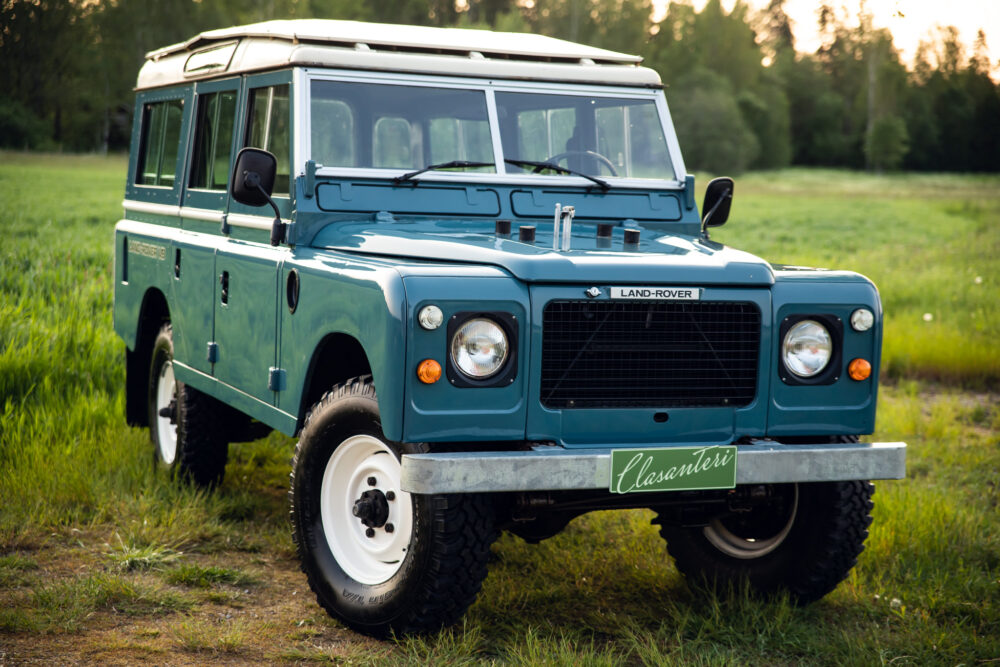 Vintage blue Land Rover on grassy field