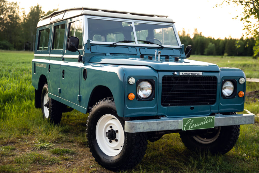 Vintage blue Land Rover in lush green field