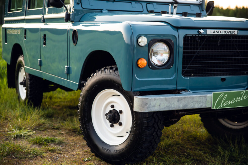 Vintage blue Land Rover on grassy field