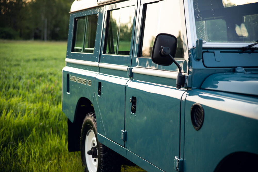 Vintage Land Rover V8 parked in lush green field