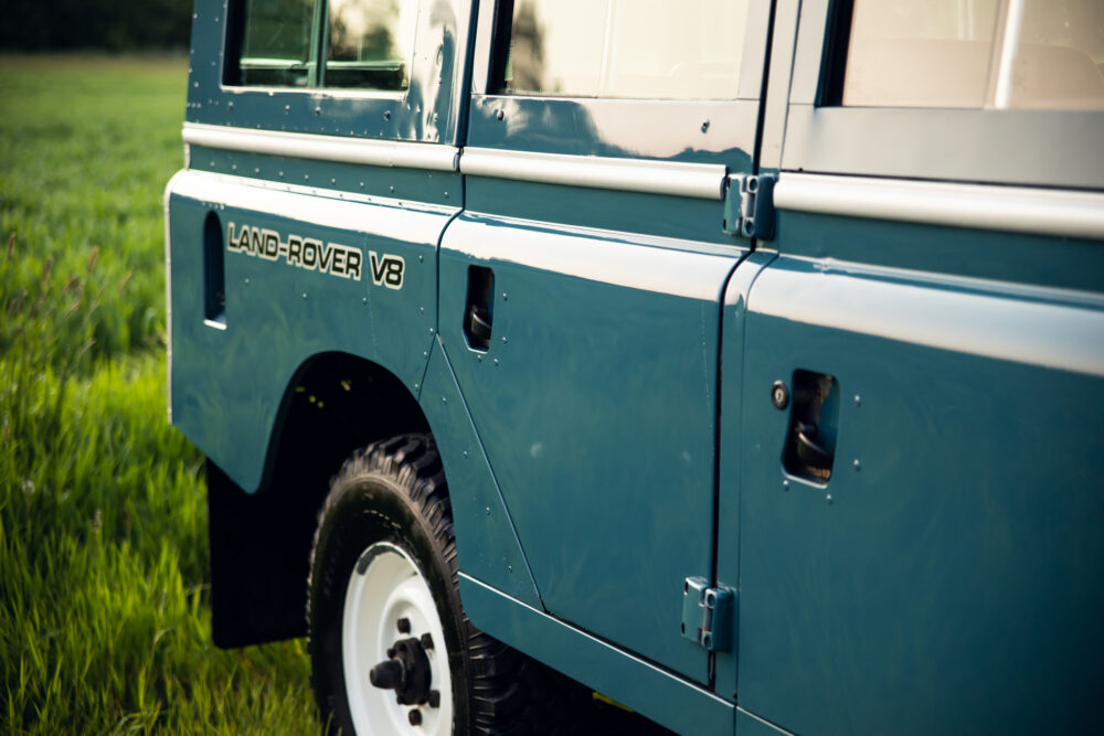Close-up of a blue Land Rover V8 in a field