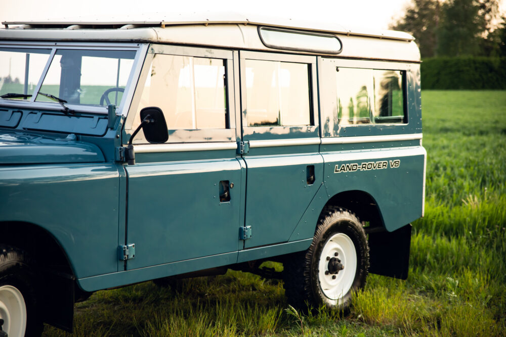 Blue vintage Land Rover V8 in a green field