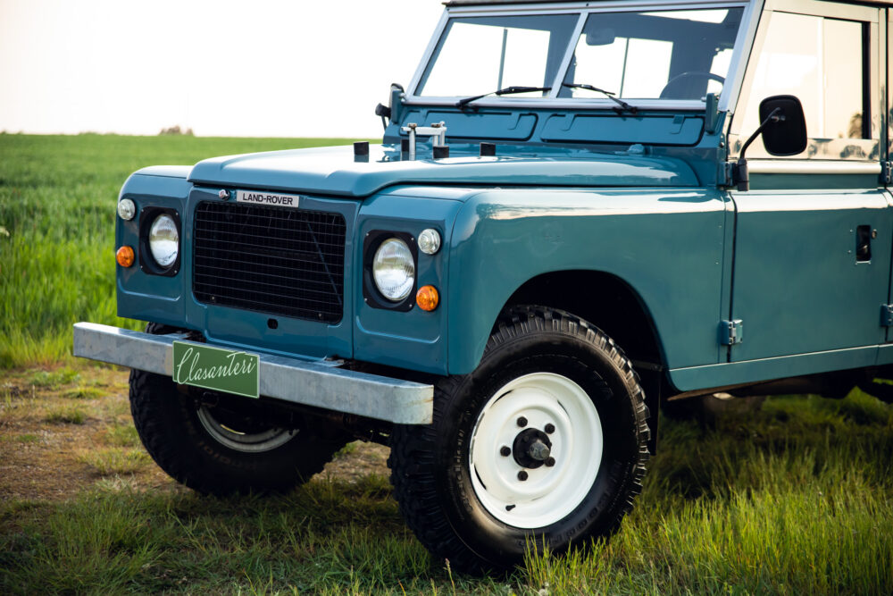 Vintage blue Land Rover parked on green grass