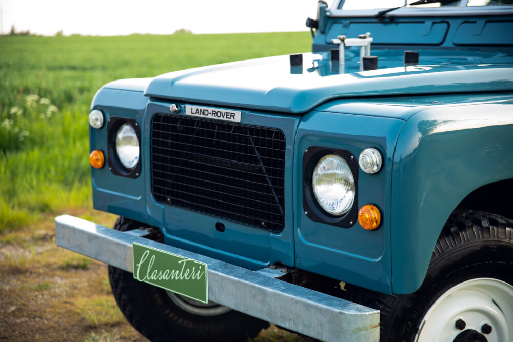 Blue Land Rover with Clasanteri plate in green field