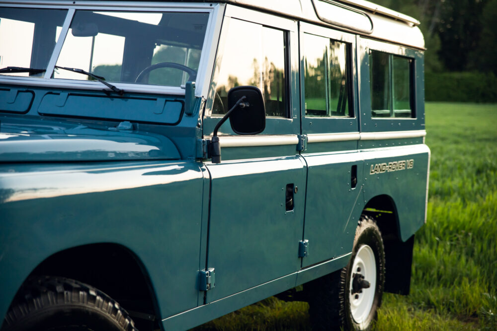Vintage blue Land Rover on lush green field