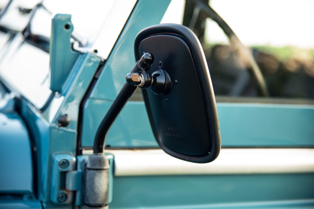 Close-up of vintage car's side mirror and hinges