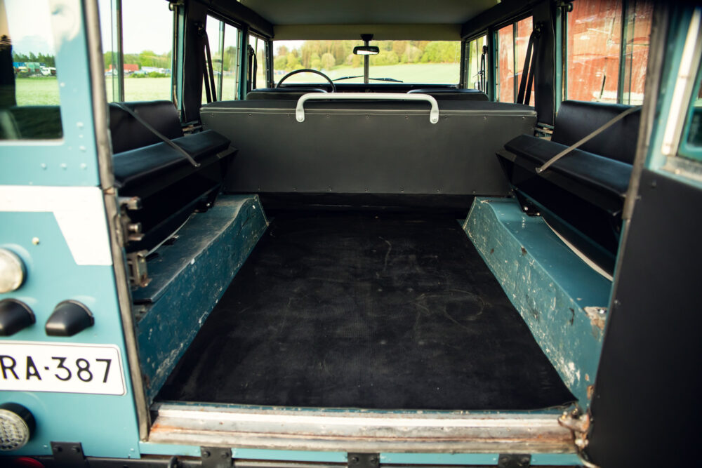 Interior view of empty vintage bus with open back door.