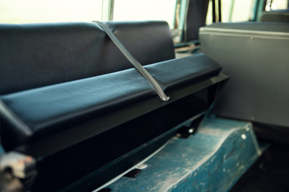 Empty bus seat with a gray safety belt