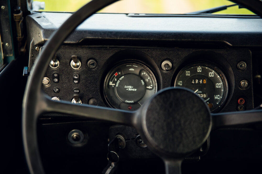 Vintage Land Rover dashboard with gauges and steering wheel.
