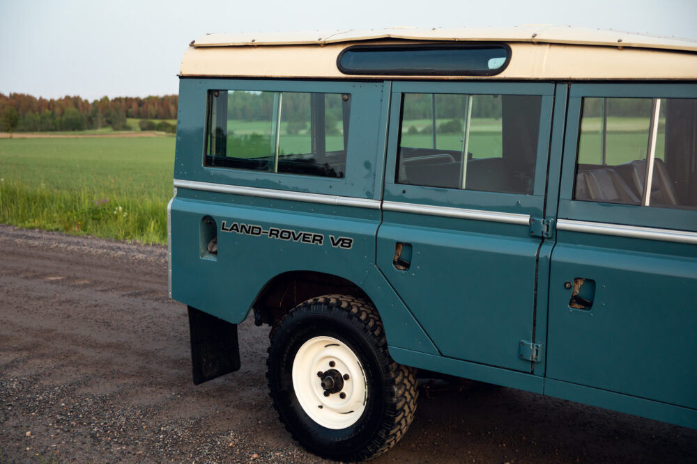 Vintage teal Land Rover V8 parked in rural setting