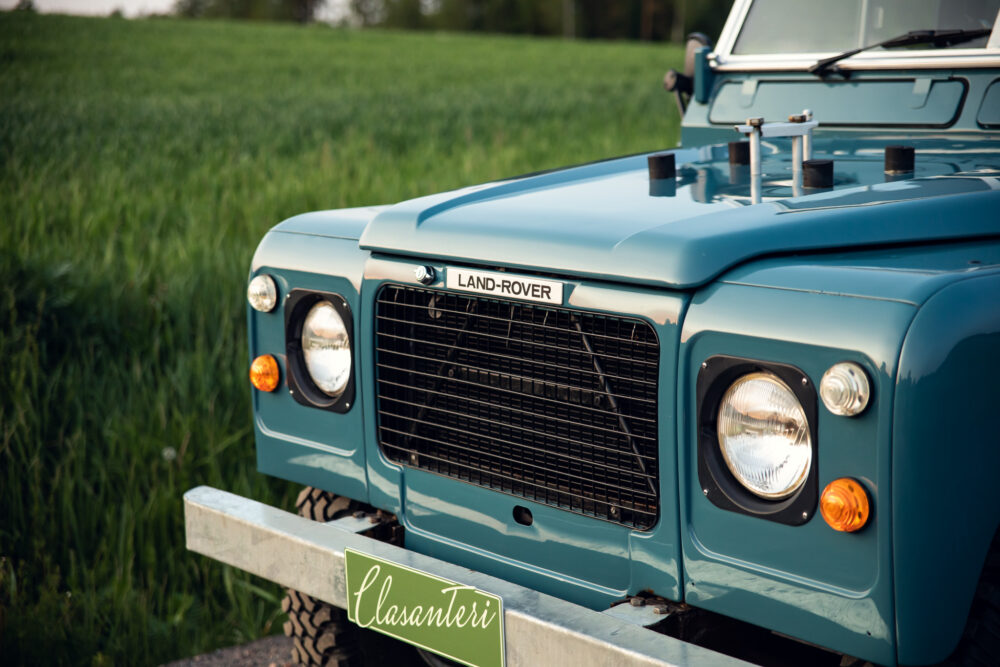 Vintage blue Land Rover in green field