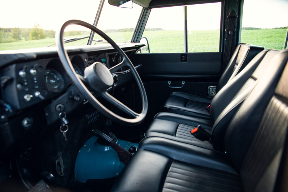 Interior view of vintage vehicle with lush field outside