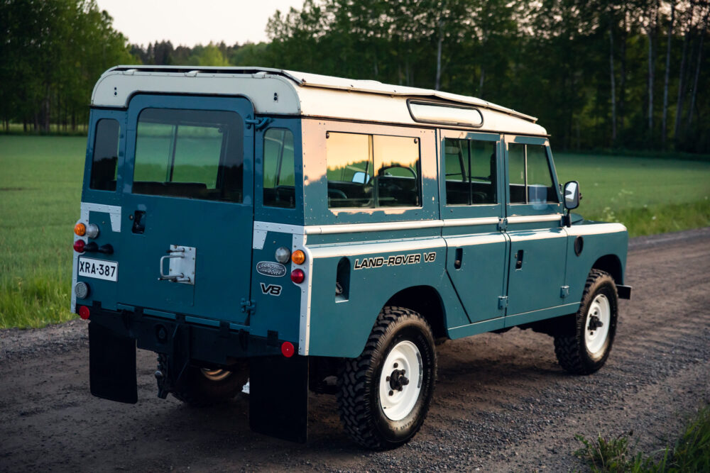Blue Land Rover V8 parked in countryside at dusk