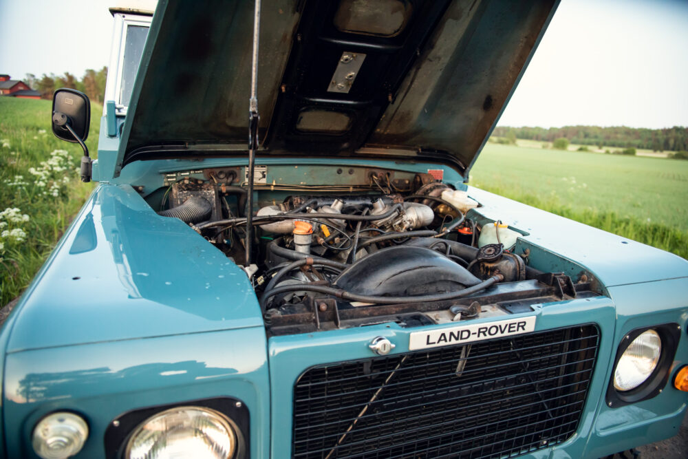 Land Rover hood open showing engine in rural setting