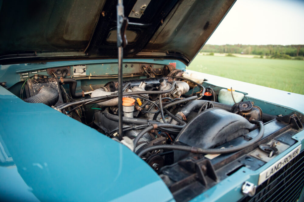 Vintage Land Rover engine compartment open in field