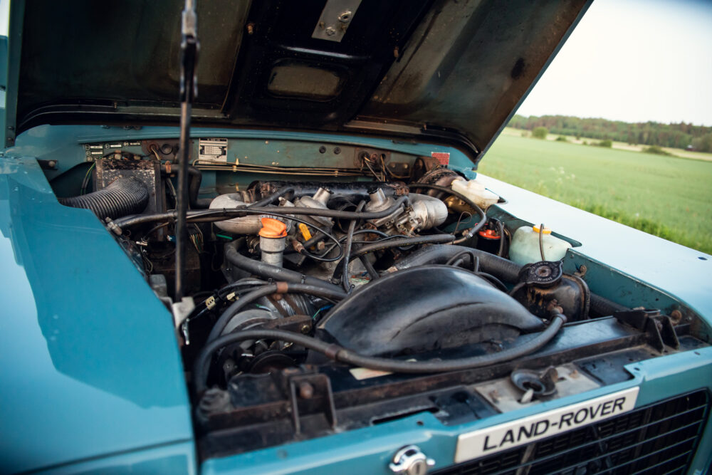 Open engine hood of a blue Land Rover