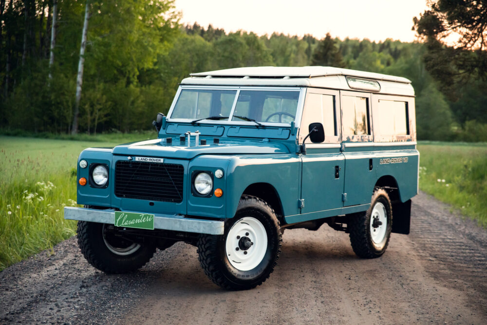 Vintage blue Land Rover on a forest road