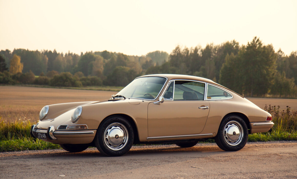 Vintage Porsche car parked on countryside road at sunset