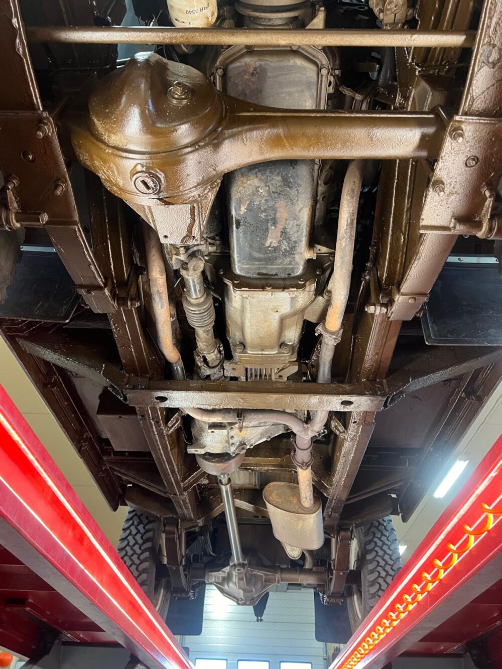 Undercarriage view of a vintage vehicle on lift
